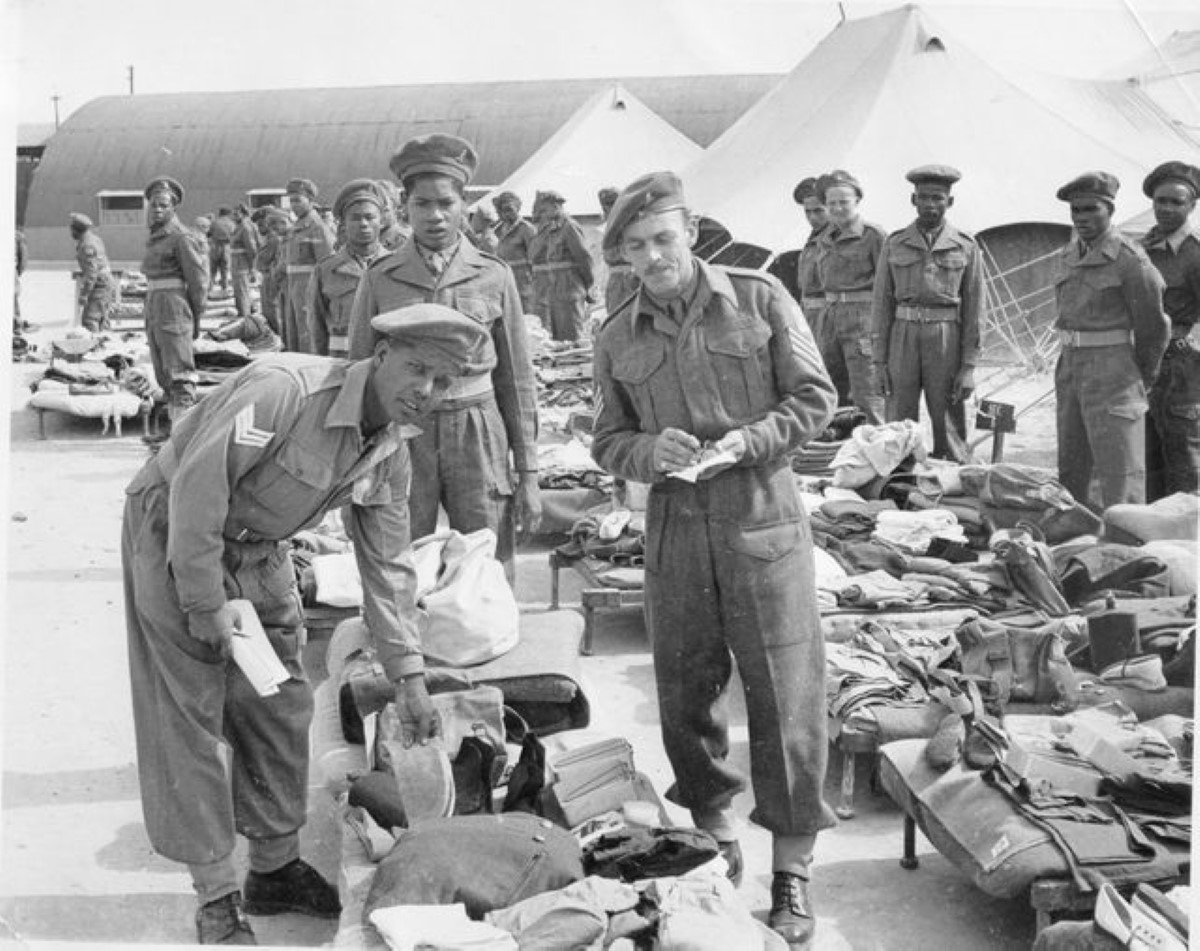 The photo shows Sgts Juggernauth and Donaldson on the foreground of 2 Trg Coy inspecting Mauritian soldiers' gear soon after they had landed in North Africa.