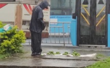 L'image du jour : A St-Pierre, sous la pluie, il vend ses mangues sur le trottoir